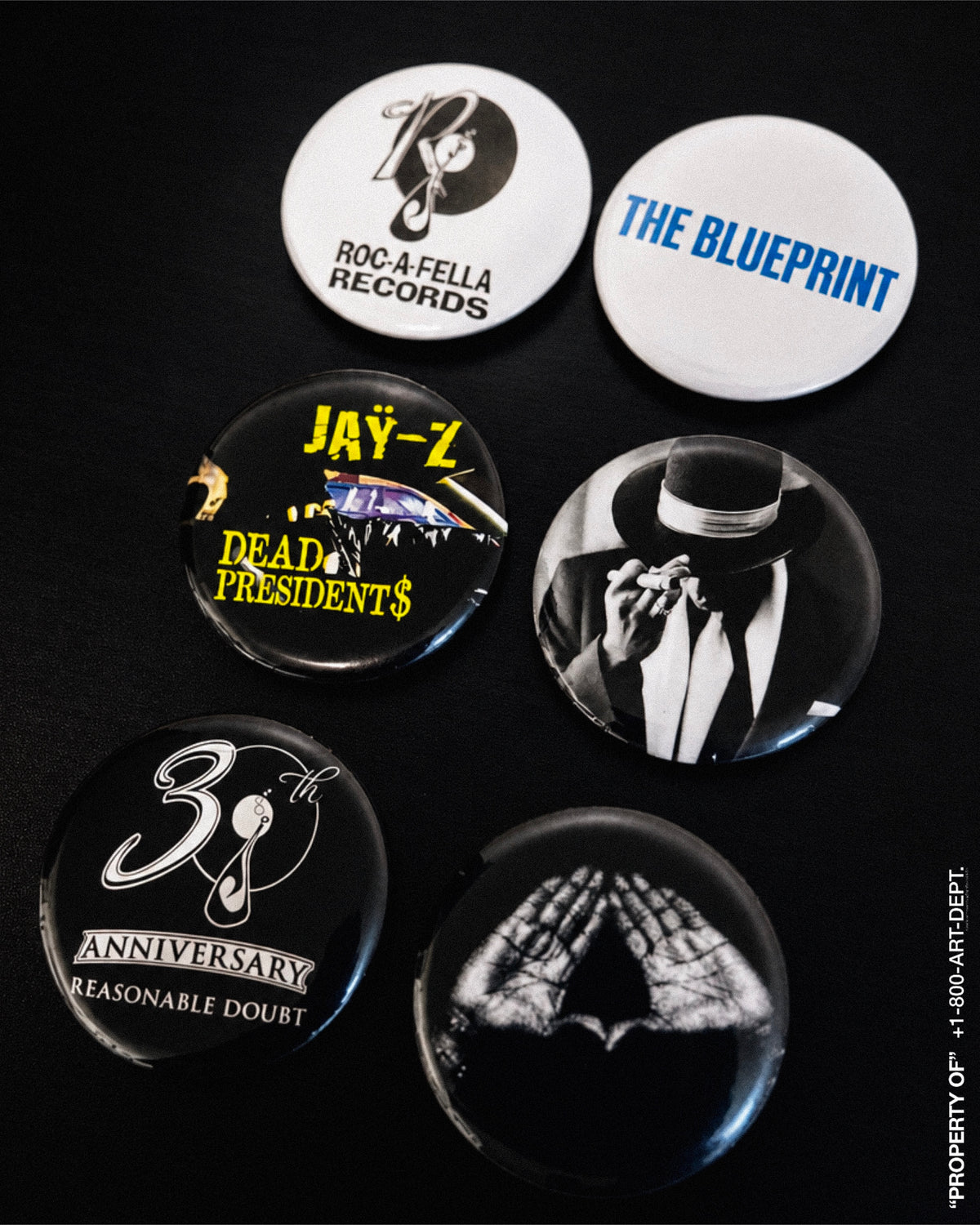 Six commemorative hip-hop graphic buttons from Untitled_Artwork 593.jpg, featuring the Roc-A-Fella Records logo, The Blueprint text, the Roc diamond hands sign, and Reasonable Doubt 30th Anniversary emblems arranged symmetrically.